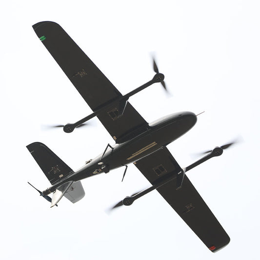 Black fixed-wing UAV with dual propellers, swept wings, and payload modules.